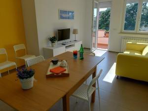 sala de estar con mesa de madera y sofá en Big Sabaudia, en Sabaudia