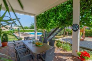 a patio with a table and chairs and a pool at Holiday house Anetta with 5 bedrooms in Imotski +55 photos