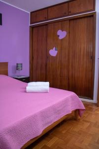 マシコにあるSpot Matur Apartmentのベッドルーム1室(ピンクベッド1台、木製キャビネット付)