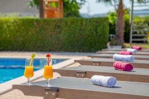 a table with two glasses and towels and a pool at Holiday house Anetta with 5 bedrooms in Imotski