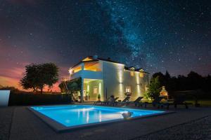 a house with a swimming pool at night at Holiday house Anetta with 5 bedrooms in Imotski