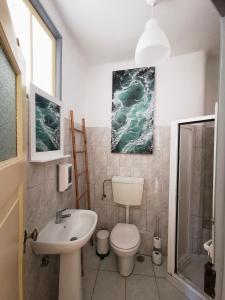 a bathroom with a white toilet and a sink at Casa da Ferraria in Sintra