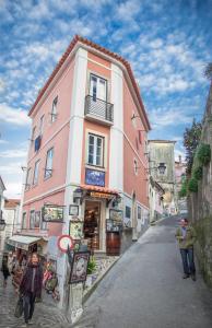 een groep mensen die in een straat naast een gebouw lopen bij Casa da Ferraria in Sintra