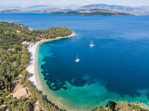 una vista aerea di una spiaggia con due barche in acqua di Agios Stefanos Bay - Villa Anna ad Ágios Stéfanos