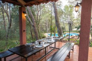 a dining table on a patio with a view of a pool at AldeaMia, Cozy villa for 8 people, pool, mountain view, beach at 8 min in Vilanova de Escornalbou
