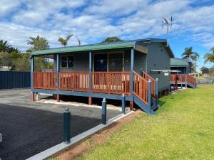 a small house with a deck on the side of a street at Amaroo Resort in Sussex inlet