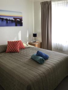 A bed or beds in a room at The Peninsular Merimbula