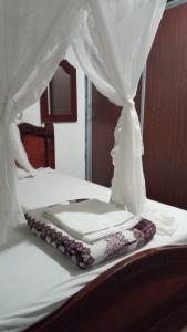 a white bed with a canopy on top of it at Ayawaska Atractivo Sacha Wasi in Nueva Loja