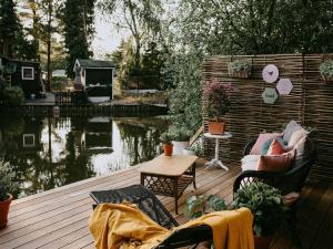 a deck with chairs and a table next to a pond at Chalet in Geel in quiet location by the water in Geel
