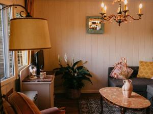 a living room with a couch and a table at Chalet in Geel in quiet location by the water in Geel