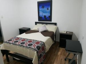 a bedroom with a bed and a picture on the wall at Hotel La Posada in Belén de Umbría