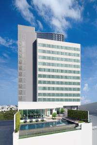 un gran edificio blanco con una piscina frente a él en Centre Point Hotel Terminal21 Korat en Nakhon Ratchasima