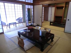 een woonkamer met een houten tafel en stoelen bij Leo Plaza Hotel in Sasebo