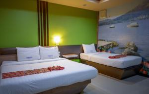 a hotel room with two beds and a painting on the wall at Thansila Resort&Garden Buriram in Buriram +27 photos