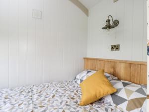 a bedroom with a bed with a yellow pillow at Waylands in Faringdon