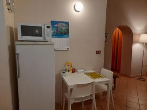 a kitchen with a table and a microwave on top of a refrigerator at Casa Elisa in Cosenza