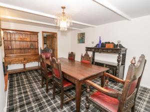a dining room with a wooden table and a piano at 35 Upper Quay Street in Amlwch