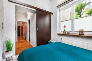 a bedroom with a blue bed and a window at Apartamenty4you - SleepWell Apartment in Sopot +38 photos