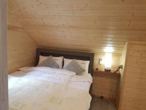 a bedroom with a bed in a wooden cabin at Domek Shrek in Boszkowo
