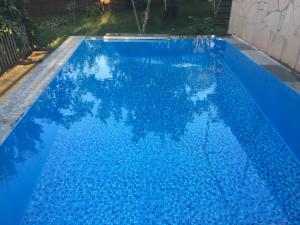 una piscina azul con reflejo en el agua en Hause en Tskaltubo