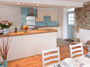 a kitchen with a table and chairs in a room at Rose Cottage in St Austell
