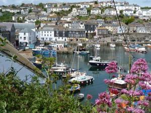 a harbor with boats in the water and a town at Rose Cottage in St Austell