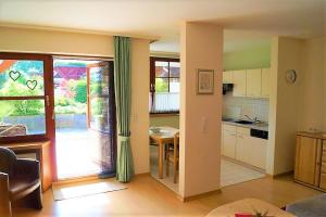 a kitchen with a door open to a dining room at BodenSEE Apartment Kressbronn "SeeLand" in Kressbronn am Bodensee