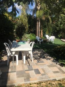 una mesa blanca y sillas en un patio en בית מרום en Gan Shomeron
