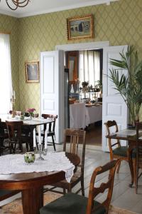 a dining room with tables and chairs and a room with a kitchen at Kvarnbo Pensionat in Saltvik