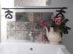 a vase with flowers sitting on a bathroom sink at Flaneurstudio in Szentendre