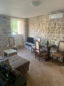 a living room with a couch and a stone wall at Apartman Dado in Perast