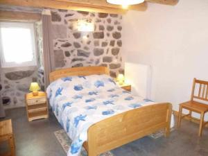 a bedroom with a bed and a stone wall at Gîte charmant pour 8 pers à Rauret avec cheminée, terrasse et accès "Tourisme et Handicap" - FR-1-582-186 in Rauret