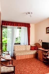 ein Wohnzimmer mit einem Sofa und einem Fenster in der Unterkunft Beatrix Hotel in Budapest