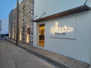 um sinal para um restaurante na lateral de um edifício em NISSEA Boutique Hotel em Kardamaina