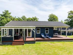 a blue tiny house with a large deck at Tranquil Oasis in Rindby in Fanø