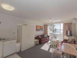 Una sala de estar con un sofá, una mesa y sillas. en Horizons 213/10 Kosciuszko Road, en Jindabyne