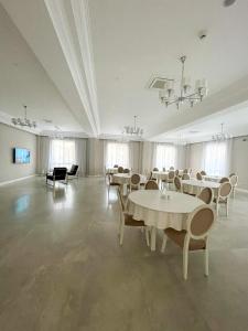 uma grande sala com mesas e cadeiras e um lustre em Pensiunea Agroturistica Marco em Uisenteş