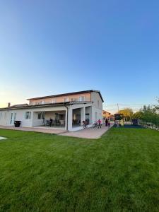 a building with a green field in front of it at Pensiunea Agroturistica Marco in Dumbrăviţa