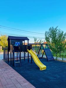 a playground with a slide and a play structure at Pensiunea Agroturistica Marco in Dumbrăviţa