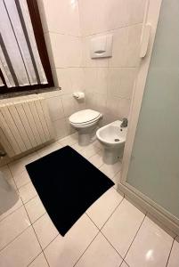 baño con aseo y alfombra negra en Casa Teresa INT 7 piano terra, en Vigevano