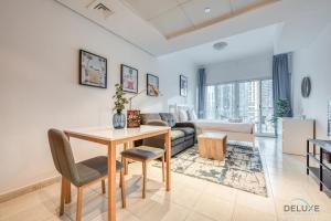 a living room with a table and a couch at Calm Studio at Lake View Tower JLT by Deluxe Holiday Homes in Dubai