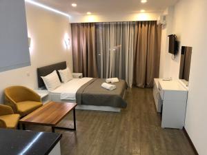 a small hotel room with a bed and a couch at panorama beach tower in Batumi