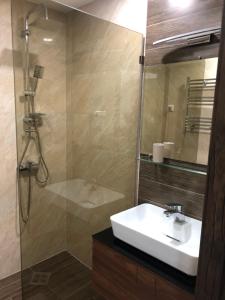 a bathroom with a sink and a shower at panorama beach tower in Batumi +28 photos