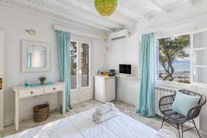 a room with a bed and a chair and a window at Xydakis Apartments in Mýkonos City