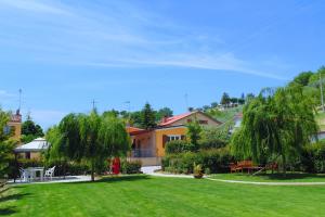 un patio con césped verde y árboles y una casa en Bigotti, en Fano