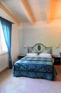 a bedroom with a bed with a blue comforter at Bigotti in Fano