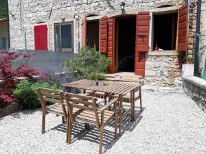 a wooden table and benches in front of a building at Casa Nonna Silla Cison di Valmarino in Cison di Valmarino