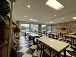 a restaurant with tables and a statue in the middle at Marina Hotel Kaikuu in Shirahama