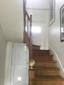 escalera con escalera de madera y puerta blanca en Numéro 7, en Le Tronquay