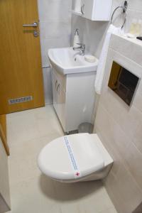 Millenium apartment في سوكو بانيا: حمام ابيض مع مرحاض ومغسلة